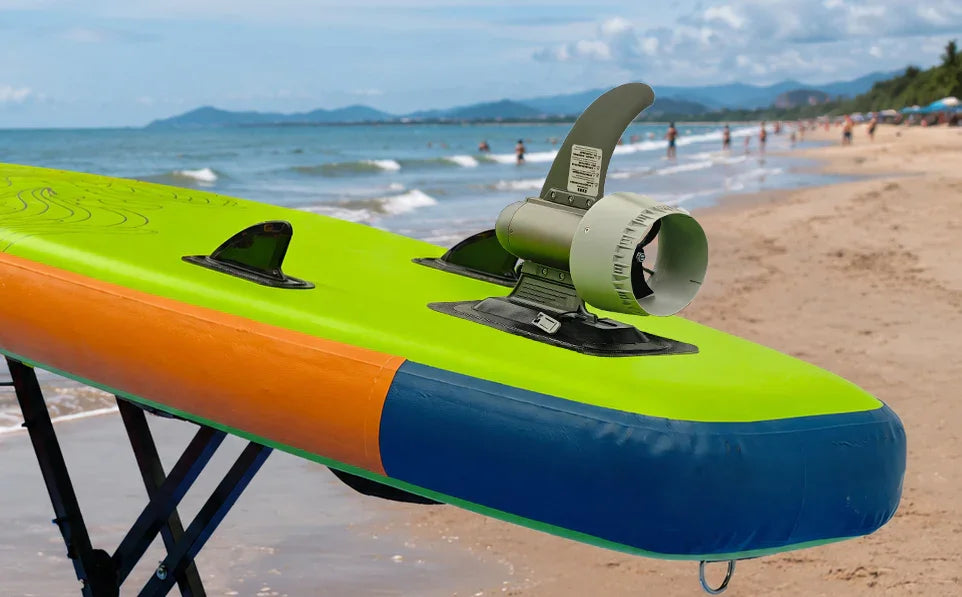 Electric fin on colorful SUP paddle board at beach, enhancing water sports with tech innovation